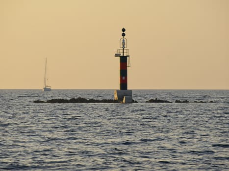 Isolated danger sea mark and  sailing boat     