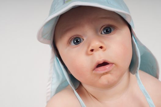 Baby boy in blue hat watching on you