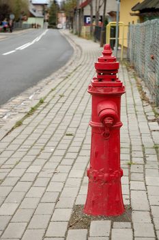 Old red hydrand standing on the street