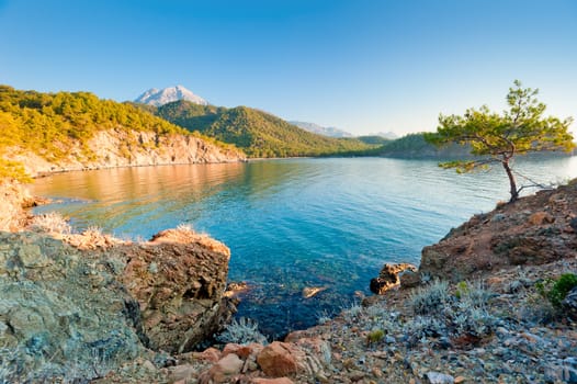 a beautiful bay with clear water and mountains