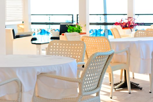 table covered with a white tablecloth and wicker chairs