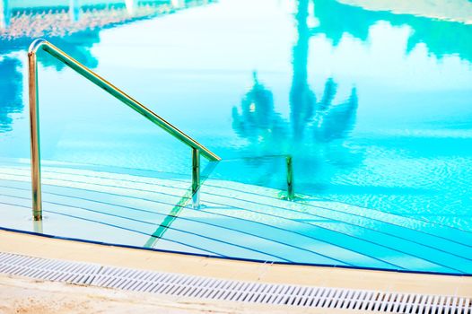 stairs leading to the blue clear water in the swimming pool