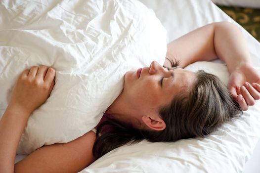 girl sleeping on her back covered with a blanke