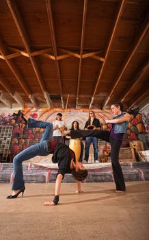 Pair of female of capoeira performers sparring together