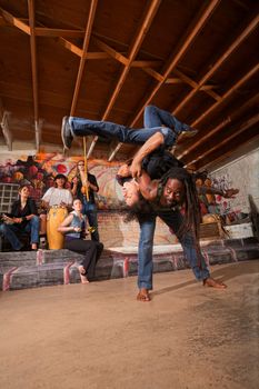 Pair of capoeira performers throwing each other over their backs