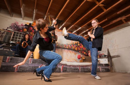 Male and female capoeira performers practicing kicks