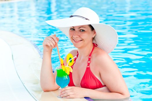 girl in the pool with a cocktail smiles