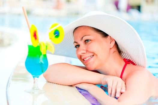 beautiful woman resting on the edge of the pool