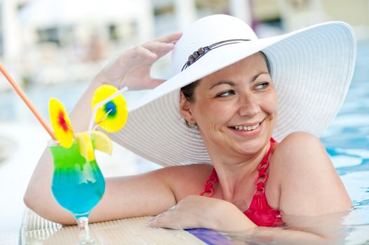 beautiful woman in a hat and cocktail