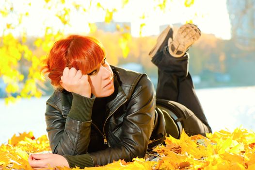 girl lying on yellow autumn leaves