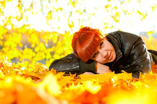 woman with red hair and yellow leaves around it