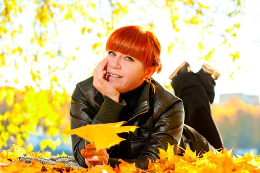 woman in the autumn park and maple leaves