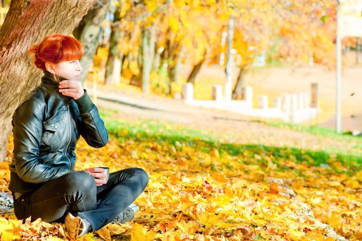 girl sitting in maple autumn sunny day