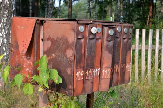 Old rusty mailboxes on the street in the village.