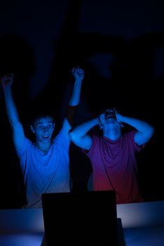 Two guys in front of a computer screen getting all excited about something