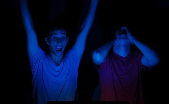 Two guys in front of a computer screen getting all excited about something