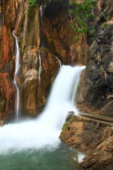 water falling to river between huge rocks 