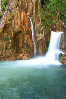 water falling to river between huge rocks 