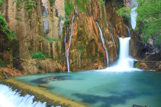 water falling to river between huge rocks 