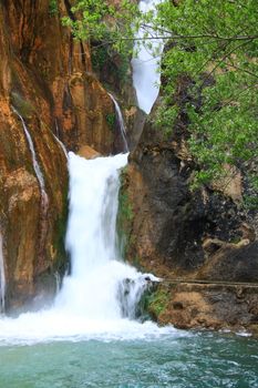 water falling to river between huge rocks 