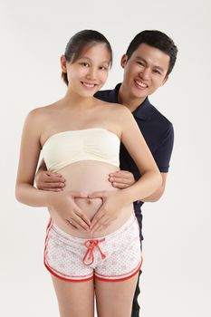 Smiling husband hugging her pregnant wife