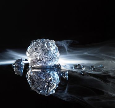 studio photography of ice crystals and smoke in black reflective back