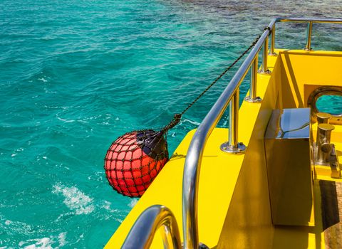 Part of fishing boat with red buoy against the sea