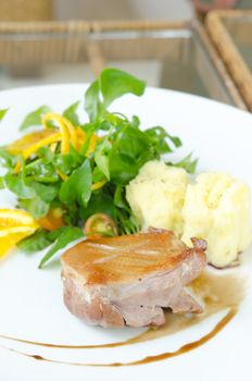 Roasted duck breast  served with mashed potatoes ,  fresh  vegetable and white wine sauce on white plate