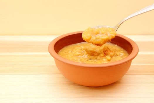 Closeup of spoonful of hearty lentil and vegetable soup lifted from the bowl