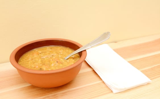 Lentil and vegetable soup ready to eat, with napkin beside bowl on table