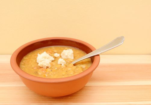Bowl full of fresh vegetable soup with torn bread pieces on top