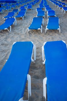 Full frame take of many deckchairs on a sandy beach