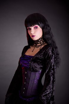 Portrait of beautiful gothic girl in Victorian style clothes, studio shot on black background 