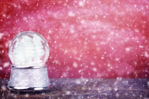 Empty Silver snowglobe against a red background with room for copy space. 