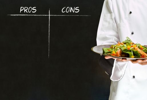 African American woman chef with chalk pros and cons on blackboard background