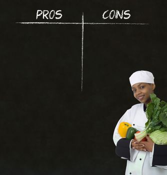 African American woman chef with chalk pros and cons on blackboard background