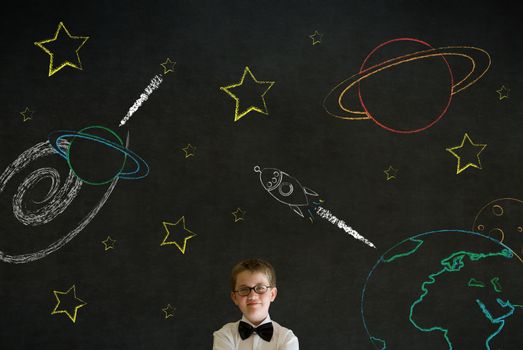 Thinking boy dressed up as business man with chalk universe planet solar system on blackboard imagining space travel