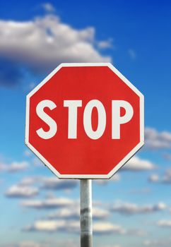 traffic sign - stop - over blue cloudy sky background