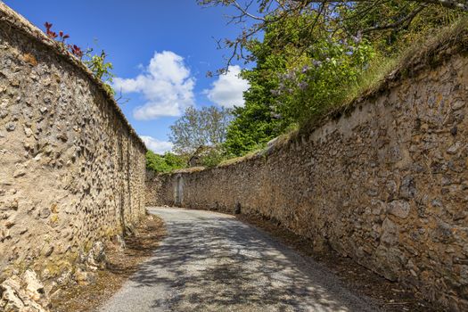 Narrow road between stone walls in a small French town