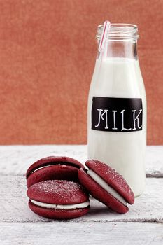 Stack of homemade Red Velvet Whoopie Pies or Moon Pies made with cream cheese frosting. 