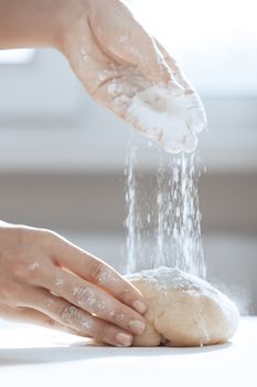 Woman preparing dough and flouring