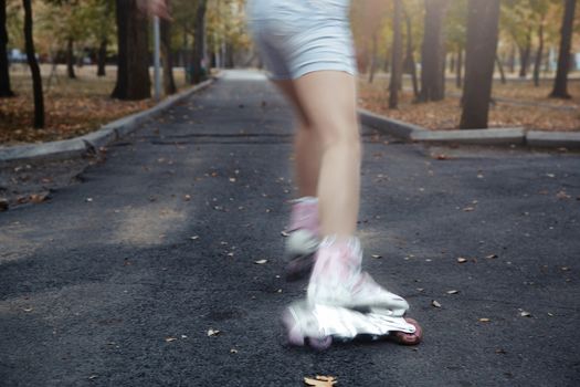 Legs of teenager having roller skate exercise in public park