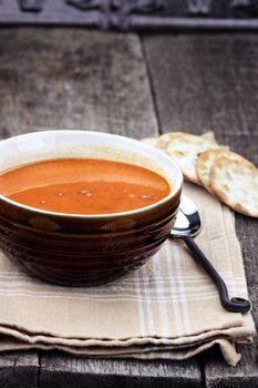 Tomato Bisque with crackers over a rustic background. 