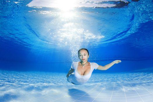 athletic girl diving under the sea