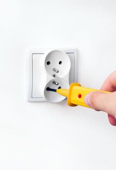 Man checking power in socket with detector