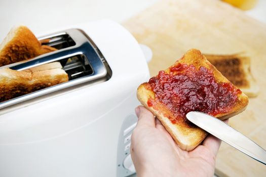 Preparing toast with jam for breakfast