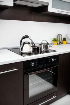 Saucepan, kittle and frying pan in modern kitchen