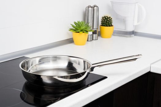 Frying pan in modern kitchen with induction stove