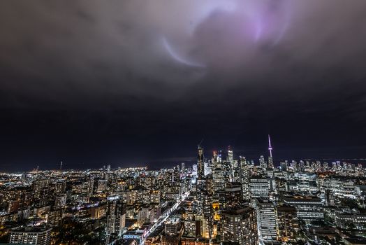 Full view of downtown Toronto at night with glamour spotlights pattern in the sky