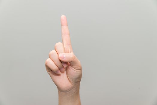 Human hand with one finger sticking up on light gray background